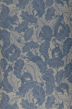 a blue and white wallpaper with leaves and flowers on the back half of it