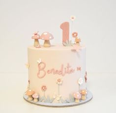 a white cake with pink decorations and the number one on it