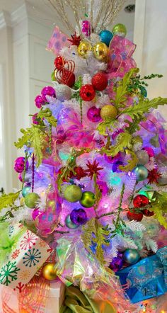 a brightly colored christmas tree decorated with ornaments