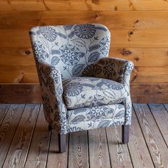 a chair sitting on top of a wooden floor next to a wood paneled wall