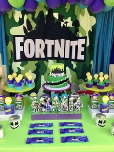 a table topped with cake and cupcakes covered in green frosted icing