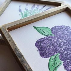 three framed pictures with flowers painted on them, one is purple and the other has green leaves