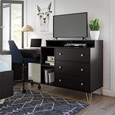 a bedroom with a desk, chair and television on it in front of a window