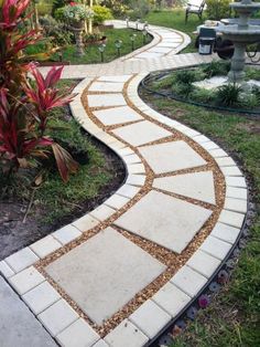 a walkway made out of pavers in the middle of a garden