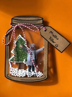 an ornament in a jar with a christmas tree inside