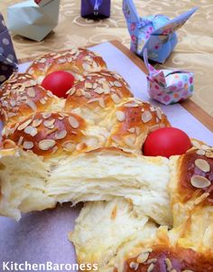 a pastry with red balls on it sitting on a table next to origami birds