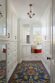 a room with white cabinets and a blue rug