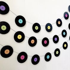 there are many different colored records hanging on the wall, and one is made out of black vinyl