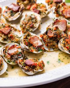 a platter filled with cooked oysters covered in sauce