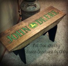 a wooden bench with the word john deer painted on it's bottom and foot