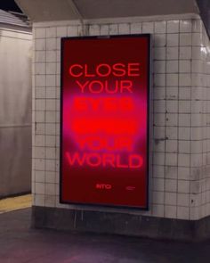 a red sign that says close your eye to the world in front of a subway station