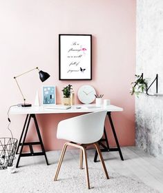 a white desk topped with a computer monitor next to a clock