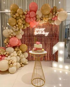 a birthday cake on a table in front of balloons