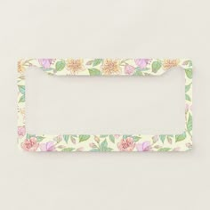 a white frame with flowers and leaves painted on the front, in pastel colors