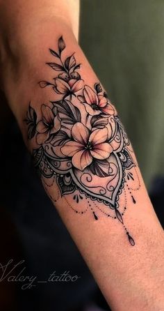 a woman's arm with flowers on it and an ornate frame around the wrist