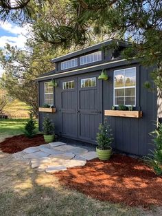 a small shed with plants in the windows