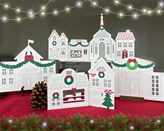 a group of white houses with christmas decorations on them