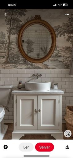 a bathroom with a sink, toilet and mirror on the wall next to a basket