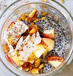 a glass bowl filled with fruit and oatmeal on top of a table