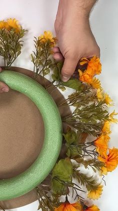 someone is making a wreath out of fake flowers