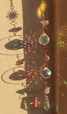 the sun is shining on a wall with some glass beads hanging from it's side