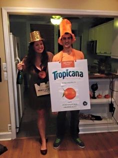 two people in costumes holding up a sign that says tropicana with oranges on it