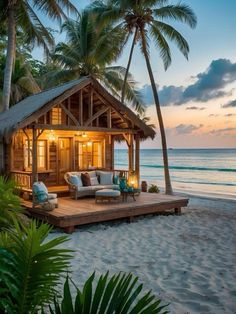 a small wooden cabin sitting on top of a sandy beach next to the ocean with palm trees