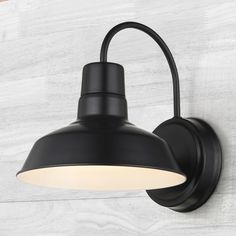 a black wall light with a white shade on the top and bottom half of it