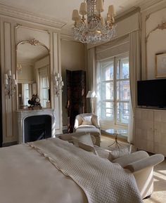 a bedroom with a large bed and chandelier in the corner next to a fireplace