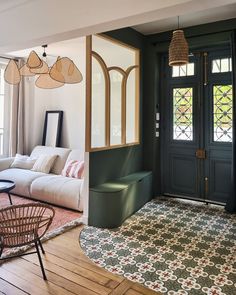 a living room filled with furniture and lots of windows next to a doorway that leads to a patio