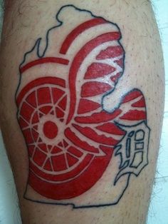 a red and white tattoo on the leg of a man