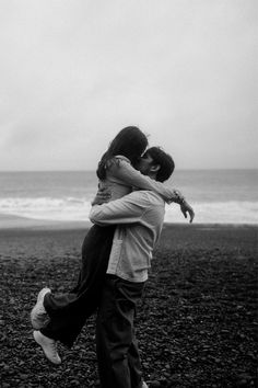 two people hugging each other on the beach