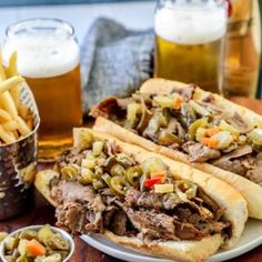 two sandwiches on a plate with french fries and beer