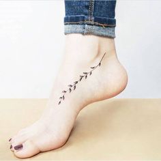 a woman's foot with a small flower tattoo on the side of her leg