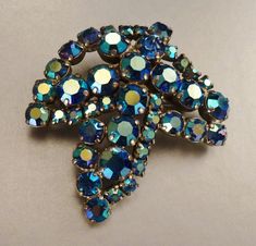 "A stunning brooch and clip on earrings unsigned set, silvertone with brilliantly colorful handset faceted blue irridescent aurora borealis rhinestones as you can see from the pictures. All pieces are in excellent vintage condition and measure; brooch a large 2 3/8\" by 2 1/4\" inches wide and the earrings measure 1 3/8 by 3/4 inches.. A stylish stunning earrings and brooch set addition to your wardrobe, a bride's heirloom something blue to wear and be trasured!" Iridescent Brooch Jewelry Gift, Iridescent Brooch Jewelry For Gifts, Iridescent Brooch Jewelry For Party, Stunning Earrings, Blue Rhinestones, Something Blue, Vintage Costume Jewelry, Aurora Borealis, Vintage Costumes