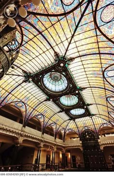 an ornate ceiling in the lobby of a building with stained glass and iron work on it