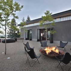 an outdoor fire pit with chairs around it