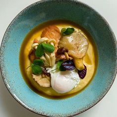 a blue bowl filled with food on top of a table