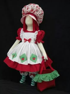 the doll is wearing a red and white dress