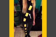 a woman with long blonde hair standing in front of a mirror wearing black and yellow striped leggings