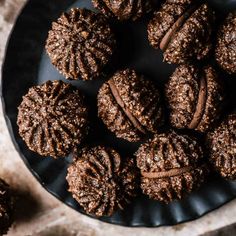 chocolate cookies are arranged on a black plate