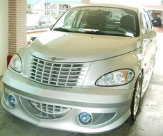 the front end of a silver car parked in a garage