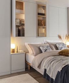 a bedroom with a bed, nightstands and cabinets