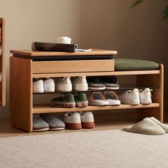 a wooden shoe rack filled with shoes next to a window