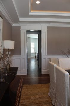 a living room filled with furniture and a doorway leading to another room on the other side