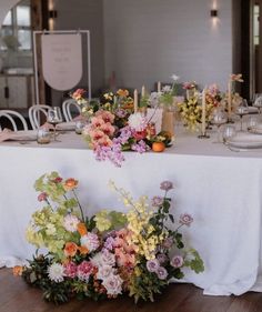 a table is set with flowers and candles for an elegant wedding breakfast or bridal party