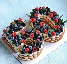 some cookies with berries and blueberries on top are arranged in the shape of a wreath