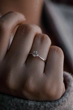 a woman's hand with a diamond ring on it