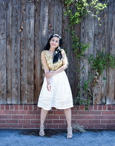 a woman standing in front of a wooden fence