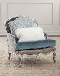 a chair with a pillow on top of it in front of a white paneled wall